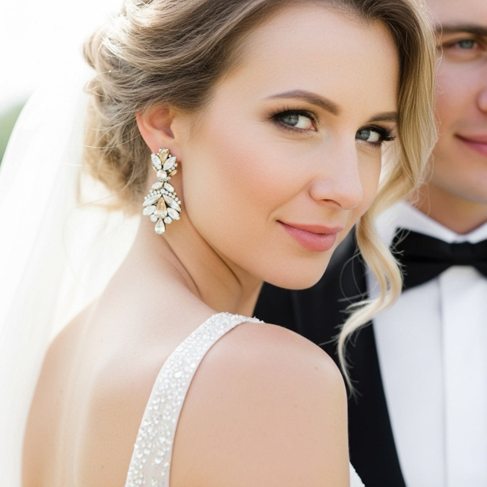 Bride wearing antique gold crystal statement earrings in wedding styling photo