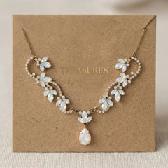Antique gold Dawn bridal necklace with Swarovski white opal marquise crystals, floral-inspired detailing and a teardrop pendant displayed on a Treasures by Agnes card.