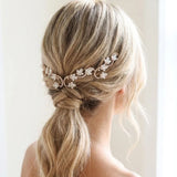Blonde bride wearing the Cleo white opal crystal bridal hair vine across a romantic low ponytail hairstyle, with delicate floral detailing and soft face-framing strands.