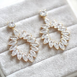 Treasures by Agnes Odette bridal earrings featuring marquise cut cubic zirconia in a gold plated open teardrop design displayed on a soft velvet jewelry box.